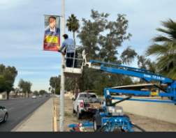 maintenance worker hanging a banner